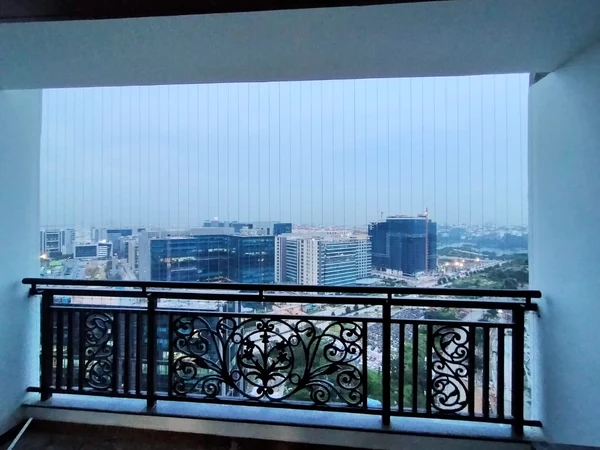 An evening view of vertical cables above the balcony railing.